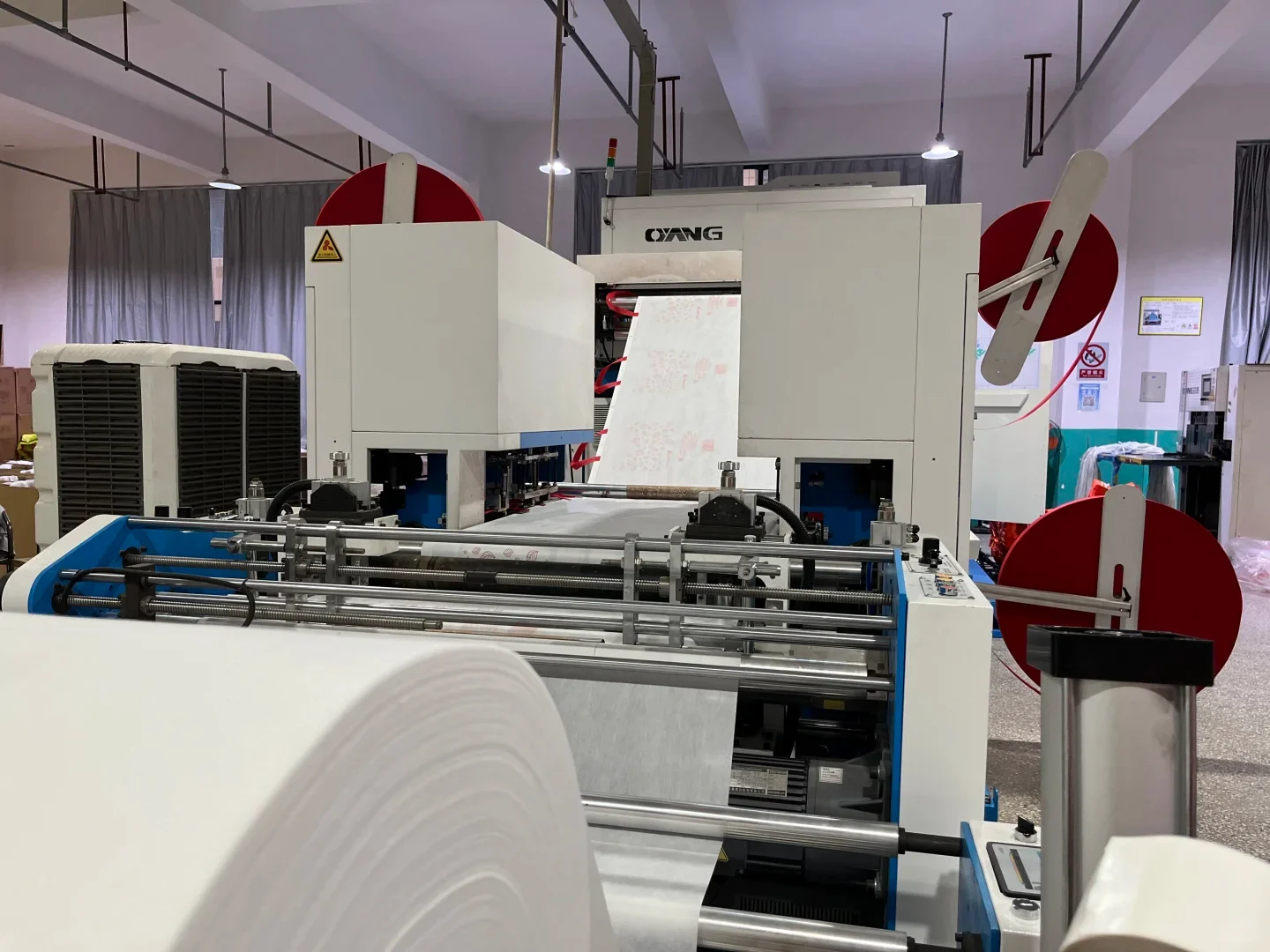 Non-woven bag making machine with white fabric rolls in our factory